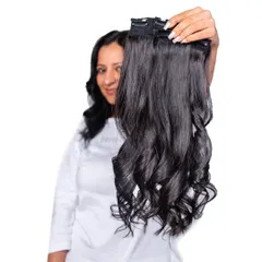 A model holding up a set of our wavy clip-in extensions. You can see the quality and natural curl pattern that will blend beautifully with your own hair.