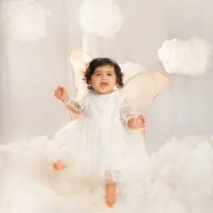 A little angel dancing on clouds for her first birthday. This is from my 'Journey to One Year' series, where I design magical studio setups like this dreamy cloud theme to celebrate your baby's biggest milestones.