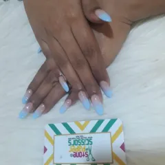 A beautiful blue ombre effect on long stiletto extensions. The color transitions smoothly from a natural nude at the cuticle to a bright sky blue at the tip.