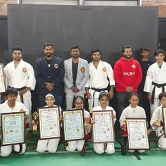 Our newly promoted black belts and senior belts posing with their certificates after a rigorous examination. This is a huge milestone.