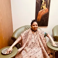 We believe in pampering all our guests. A senior client is seen here enjoying her manicure session, wrapped in a comfortable cape.