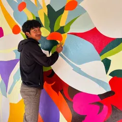 A shot of me smiling while working on the colorful abstract section of the Ziro college mural. This project was filled with good vibes and new friends.