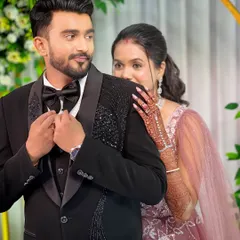 The couple looking glamorous for their reception. The groom's look is classic and sharp in a black tuxedo.