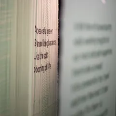 A macro view of the layered fabric from the 'Cherish' installation. The focus on the edge of the material reveals the subtle texture of the weave and the precise application of typography, showing how every tiny aspect adds to the narrative.