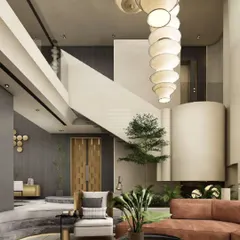 This contemporary living room is designed for both grandeur and tranquility. A double-height space is anchored by a sculptural paper lantern chandelier, while a large orange sofa adds a warm, inviting touch to the minimalist interior.
