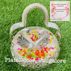 A playful arrangement in a silver swan basket, filled with colorful gem-like candies. This is a fun option for children's events or puberty ceremonies.