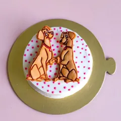 A close-up of our Valentine's cake, featuring a sweet "Lady and the Tramp" inspired cookie topper. It's the perfect way to show your pup some love.