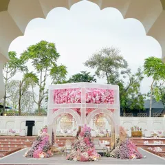 Framed by the venue's grand archway, the pink floral mandap stands as a breathtaking centerpiece. This perspective highlights how I integrate my designs with the existing architecture to create a cohesive vision.