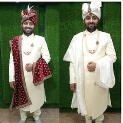A happy groom trying on two different looks for his big day. We can create multiple styles with the same sherwani by just changing the stole, from a rich velvet maroon to a classic white, giving you versatility and elegance.
