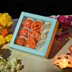 My Mithai Candle Gift Box, elegantly packaged in a pastel blue box with a clear window. This packaging is designed to showcase the intricate details of the Laddoo, Jalebi, and Kaju Katli candles inside, making it a perfect ready-to-gift option.