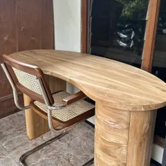 A custom-made study desk with a kidney-bean-shaped top and a cylindrical pedestal base. Paired with a Cesca-style chair, this makes for a stylish and functional home office setup.