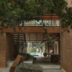 We preserved the natural landscape by incorporating existing trees and large boulders into the courtyard design. This view from the gravel court looks through the open dining area towards the pool.