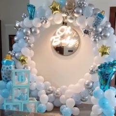 An elegant and modern 'Oh Baby' setup, perfect for a baby shower or welcome home party for a boy. This design is built around a full circular balloon arch in pastel blue, white, and chrome silver, with a central neon sign. I also include themed props like 'BABY' display boxes and foil balloons shaped like baby bottles.
