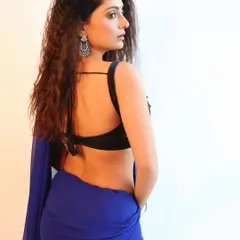 A shot from the back, showcasing the stylish design of the blouse and the elegant drape of the saree. This angle provides a complete view of the outfit.