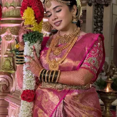A candid moment of the bride with a flower garland. The makeup is designed to be serene and unforgettable, with a focus on glowing skin that looks beautiful both in person and in photos.