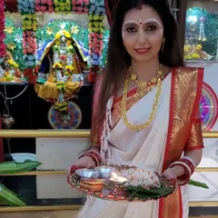 Dressed for Durga Puja, holding a traditional prayer thali. The drape is styled to be both beautiful and practical for participating in rituals, a key consideration in my teaching.