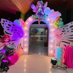 A grand entrance arch designed for the fairyland theme. It features large, illuminated butterfly wings and fairy cutouts to welcome guests into a world of fantasy.