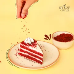 A slice of our Red Velvet Pastry being finished with a sprinkle of cake crumbs. It's the perfect balance of sweet, tangy, and velvety.
