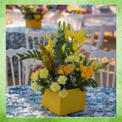 A vibrant floral centerpiece designed for a South Indian wedding event. The bright yellow flowers and custom box add a pop of color to the table, demonstrating how I use florals to enhance the theme and energy of an event.