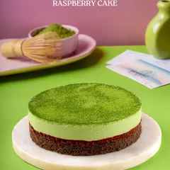 My Matcha Raspberry Cake, a perfect balance of earthy and tart. A vibrant green matcha mousse sits atop a layer of raspberry compote and a rich chocolate base.