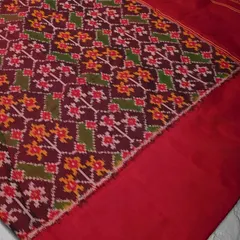 A close-up of a Patan Patola Ikkat weave, showing the intricate, multi-colored patterns. This double Ikkat weave is one of the most complex and prized textile arts in the world.