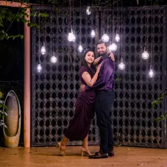 The combination of hanging Edison bulbs and the rustic gate creates an industrial-chic vibe, offering a unique and moody background for your night shoot.