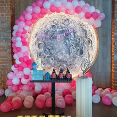 A unique "Love you to the moon and back" theme for Mishka's first birthday. The textured moon backdrop, surrounded by a pink balloon arch and complemented by a light-up name, made for a stunning celebration.