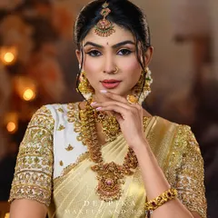 This model is wearing a complete antique gold temple jewellery set, featuring a statement choker, layered necklace, and matching earrings, all available to rent.