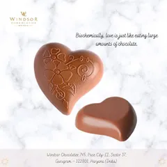 A set of two milk chocolate hearts, one with an intricate floral pattern and one smooth, showcasing different styles for a romantic gift.