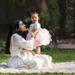 A mother and daughter sharing a sweet look in the golden afternoon light. The park setting creates a soft, dreamy background for these tender moments.