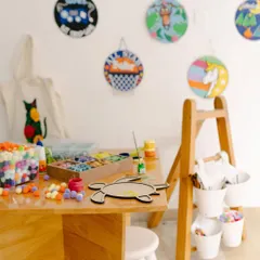 A quiet corner of the studio, ready for creativity to strike. Seeing all the materials like pom-poms, tiles, and paints laid out is so inspiring. My goal is to give you this exact "ready to create" feeling when you open one of my kits at home.