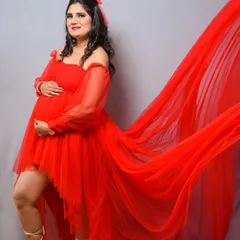 A bold and beautiful studio shot. The flowing red tulle of this gown creates a sense of drama and movement, resulting in a truly showstopping maternity portrait.
