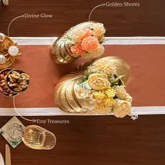 An overhead view of a beautifully layered festive table. We've combined our golden shell vases, nut bowls, and decorative platters to create a rich, textured look that is both elegant and inviting.