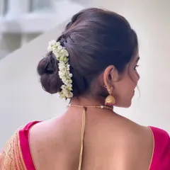 A detailed view of the braided elements leading into the gajra-adorned bun.