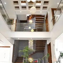 A view from the upper level looking down into a double-height atrium. This design feature creates a sense of vertical space and visual connection between the different floors of the home.