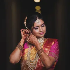 This look focuses on the rich details of a South Indian bride. The makeup features dramatic eyes and a soft pink lip, perfectly complementing her intricate diamond jewellery and the vibrant colours of her saree.