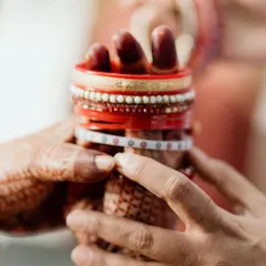 A detail shot of the bride's hands holding her bangles, a mix of Odia and Telugu traditions. Capturing these blended details is key to telling the story of an inter-cultural wedding.