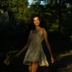 Playing with light and shadow in a natural setting. The way the sun highlights her face while the background remains dark creates a beautiful, focused portrait.