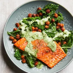 A perfectly cooked salmon fillet on a bed of fresh kale and roasted chickpeas, topped with a creamy dill sauce. This is an example of my premium non-vegetarian meals, rich in Omega-3s and designed for clean eating.