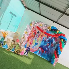 This angled view shows the complete setup for the Children's Day event, including character cutouts of superheroes and princesses, creating an exciting photo opportunity for the kids.