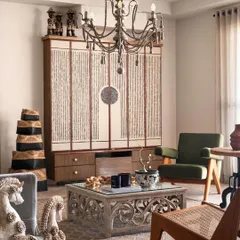 A close-up of the living area, highlighting the carved wooden coffee table and the custom-designed cabinet. Each piece was chosen for its unique character and craftsmanship, contributing to the home's soulful feel.