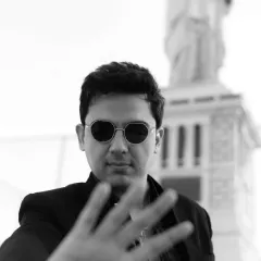 A creative black and white portrait with a shallow depth of field. The hand in the foreground adds an artistic and engaging element to the shot.