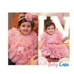 Ruffles for our little doll. This soft pink ruffled dress is all about texture and fun, designed to be as joyful and bubbly as the little girl wearing it. It's a perfect choice for a cake-smash photoshoot or a first birthday party.
