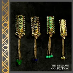 Our collection of long, dangling brooches with colored beads. These pieces feature detailed enamel work on a gold-tone base and are finished with hanging chains and beads in green and blue.