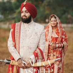 A regal portrait of the Sikh groom in his sherwani, holding the kirpan, with his bride in the background. We create classic portraits that honor the traditional attire of a Punjabi wedding.