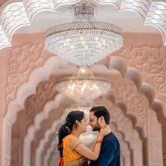 A grand and architectural pre-wedding portrait. The repeating arches and magnificent chandelier create a stunning, regal backdrop for Sayali and Siddhesh's romantic photo.