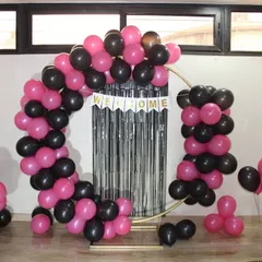 Another look at the circular welcome home arch. The pink and black balloons are arranged to create a dynamic, asymmetrical design that is both modern and celebratory.
