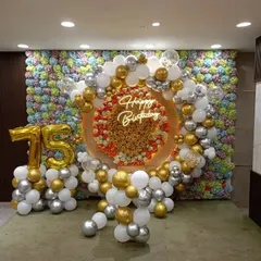 A grand setup for a 75th celebration, featuring large golden foil balloon numbers. Paired with a flower wall and balloon arch, these numbers ensure the milestone is the star of the show.