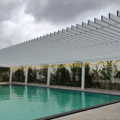Shaded sophistication meets poolside perfection. This sleek white pergola provides elegant shade for the swimming pool, its repeating lines creating a sense of rhythm and order.