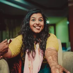 A fun and quirky shot of a bride showing off her mehendi with a playful expression. We love capturing real personalities.